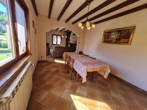 a dining room with a table and a couch at Maison tranquille avec cheminée près de Gérardmer - FR-1-589-142 in Gerbépal