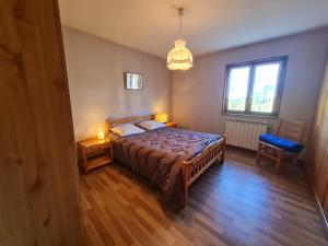 a bedroom with a bed and a table and a window at Maison tranquille avec cheminée près de Gérardmer - FR-1-589-142 in Gerbépal