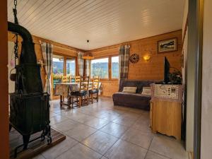 a living room with a couch and a table at Chalet rénové proche du Valtin – Idéal pour famille, randonnées et ski, Wifi, luges fournies - FR-1-589-150 in Ban-sur-Meurthe-Clefcy