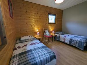a bedroom with two beds in a wooden cabin at Chalet rénové proche du Valtin – Idéal pour famille, randonnées et ski, Wifi, luges fournies - FR-1-589-150 in Ban-sur-Meurthe-Clefcy