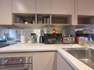 a kitchen with a sink and a microwave at 2Bed 2Bath -Pool, Balcony, Gym Lift in London