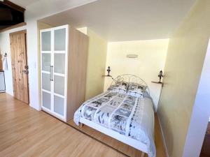 ein Schlafzimmer mit einem Bett in einem Zimmer in der Unterkunft Charmant studio dans ferme avec terrasse et parking - montagnes des Vosges - FR-1-589-164 in Le Ménil