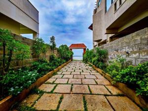 a stone walkway in front of a building at Royal Experiences Buddha Sea View Villa, Mutukadu Beach ECR Chennai in Chennai