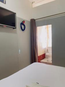 a bedroom with a bed and a mirror and a toilet at Sunrise Guest Inn in Pretoria