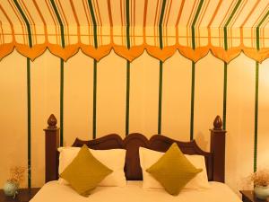 a bedroom with a bed with a striped canopy at Venture Desert Camp Jaisalmer in Sām