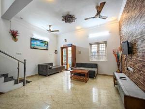 a living room with two couches and a brick wall at Royal Experiences Buddha Sea View Villa, Mutukadu Beach ECR Chennai in Chennai