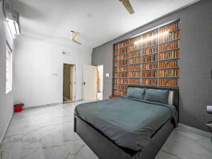 a bedroom with a bed and a wall with books at Royal Experiences Buddha Sea View Villa, Mutukadu Beach ECR Chennai in Chennai