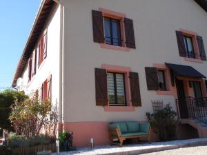 a white building with brown windows and a chair at Gîte Saint-Dié-des-Vosges, 2 pièces, 2 personnes - FR-1-589-177 in Saint Die