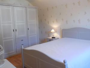 een slaapkamer met een wit bed en een witte kast bij Gîte Saint-Dié-des-Vosges, 2 pièces, 2 personnes - FR-1-589-177 in Saint Die