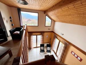 a staircase in a house with a large window at Chalet spacieux avec cheminée, proche forêt, sentiers pédestres, terrasse, terrain clos, jeux et WIFI - FR-1-589-187 in Gerbamont 