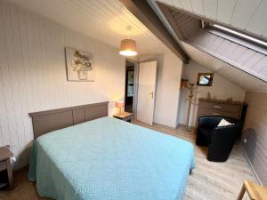 a bedroom with a blue bed in a attic at Chalet spacieux avec cheminée, proche forêt, sentiers pédestres, terrasse, terrain clos, jeux et WIFI - FR-1-589-187 in Gerbamont 