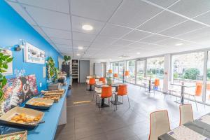 マルセイユにあるMontempô Marseille Centre Dômeの青い壁とオレンジの椅子が備わるファーストフードレストランです。 +11枚の写真