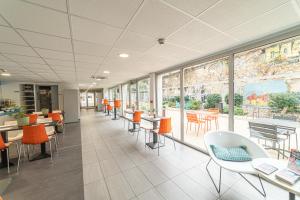 an empty cafeteria with tables and chairs and windows at Montempô Appart'Hôtel Marseille Centre Dôme in Marseille