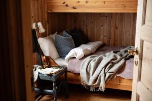 a bed with pillows and a blanket in a room at Formoseter in Høvringen