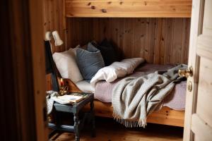 Una cama con almohadas y una manta en una habitación en Formoseter, en Høvringen