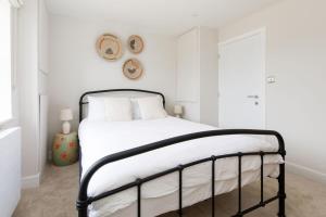 a bedroom with a bed with white sheets and white pillows at Mariners: Stylish Beachside Getaway with Sea Views in East Wittering