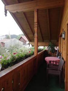 a porch with a table and chairs and flowers at Haus Hiebl in Teisendorf