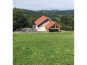 una casa in mezzo a un campo verde di Gîte Anould, 4 pièces, 6 personnes - FR-1-589-220 ad Anould