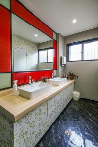 ein Badezimmer mit zwei Waschbecken und einem großen Spiegel in der Unterkunft 双龍居ホテル in Miki