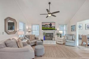 New Listing! Pelican Bay 14 -Luxury Home at Beach! في جزيرة النخيل: غرفة معيشة مع أريكة ومروحة سقف