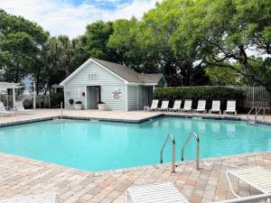 a swimming pool with chairs in front of a house at New Listing! Pelican Bay 14 -Luxury Home at Beach! in Isle of Palms