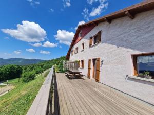 a wooden deck on the side of a building at Gîte spacieux, confort moderne, 8 pers, terrasse privative, animaux admis, WiFi - FR-1-589-227 in Vagney