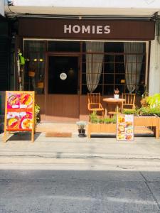 un frente de tienda con carteles delante de un edificio en Homies.Bkk, en Bangkok