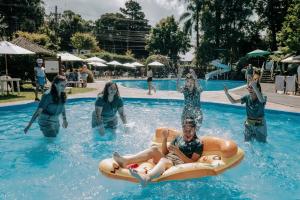 um grupo de pessoas brincando em uma piscina em Hotel Alpestre em Gramado