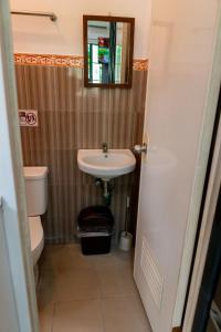 ein Badezimmer mit einem Waschbecken, einem WC und einem Spiegel in der Unterkunft Apartment near Malls in General Santos