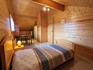 a bedroom with a bed in a wooden cabin at Chalet chaleureux avec terrasse, proche forêt et sentier, à 15 km des stations de ski de Gérardmer - FR-1-589-247 in Vagney
