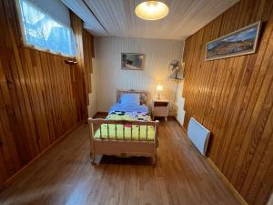 1 dormitorio con 1 cama y paredes de madera en Gîte Taintrux, 4 pièces, 5 personnes - FR-1-589-261 en Taintrux