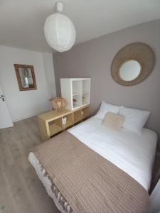 1 dormitorio con 1 cama grande y espejo en Chambre dans maison, en Baillet-en-France