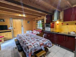 a kitchen with a large bed in a room at Chalet en bois avec jardin, proche ski et randonnée, équipé pour 8 pers. à Vagney, Vosges - FR-1-589-283 in Vagney
