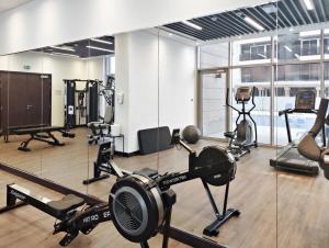 a gym with several treadmills and other exercise equipment at Silkhaus Modern 1BDR in Najmat Near Reem Central Park in Abu Dhabi