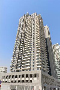 a tall building with many windows in a city at Silkhaus Modern 1BDR in Najmat Near Reem Central Park in Abu Dhabi