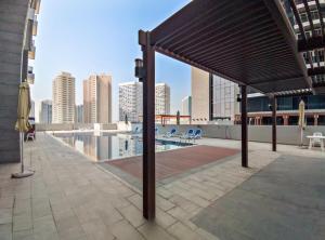 einem Pavillon auf dem Dach eines Gebäudes mit Pool in der Unterkunft Silkhaus Chic 1BDR at Najmat Near Reem Central Park in Abu Dhabi