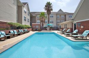 a swimming pool with lounge chairs and a hotel at Residence Inn by Marriott Austin Round Rock/Dell Way in Round Rock