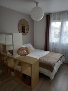 1 dormitorio con cama, mesa y ventana en Chambre dans maison, en Baillet-en-France