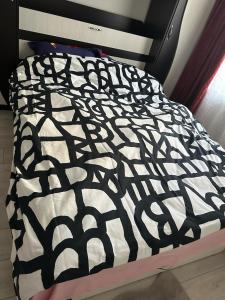 a black and white comforter on a bed at Dristor Residence in Bucharest