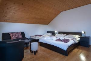 a bedroom with two beds and a couch at Vila 27 in Bešeňová