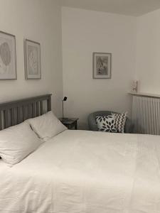 a bedroom with a large white bed and a chair at Viasavona46 Nel cuore delle Langhe in Treiso +34 photos