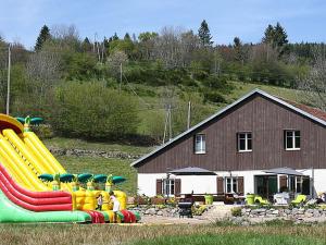 a playground with a slide in front of a house at Ferme Vosgienne rénovée avec spa, sauna, jacuzzi, billard et étang privé en pleine nature - FR-1-589-327 in Saulxures-sur-Moselotte