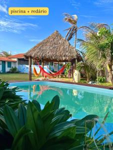São Gonçalo do Amarante的住宿－casa na Taiba - de frente ao mar - piscina - lagoa do kite，享有带游泳池和小屋的度假村景色