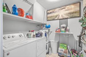 een kleine keuken met een fornuis en een wasmachine bij New Listing! Linkside Court 21 - Tennis/Pickleball in Isle of Palms