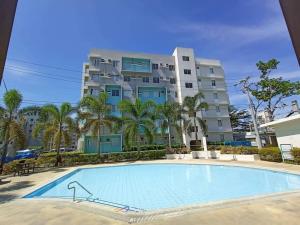 a large apartment building with a large swimming pool at Riz's 2BR & 1T/Bath Condo 8 Spatial Maa 3f in Davao City