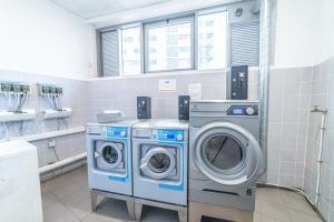 eine Waschküche mit zwei Waschmaschinen und einem Waschbecken in der Unterkunft Montempô Apparthôtel Marseille Centre Euromed in Marseille