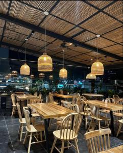 a restaurant with wooden tables and chairs and chandeliers at Zi One Luxury Hotel in Pereira