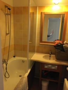 a bathroom with a tub and a sink and a mirror at Appart 1chb 4 pers 62 Résidence Vacances du Lac in Monflanquin