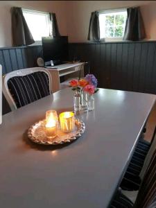 Una mesa con dos velas y flores. en Gastenverblijf Welgelheegen en Dwingeloo