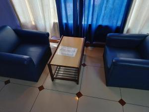 two blue chairs and a table with a sign on it at Hotel Maya international in Jaipur